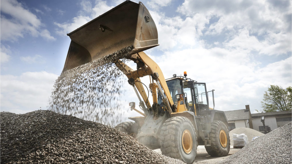 A loader making a pile of gravel.