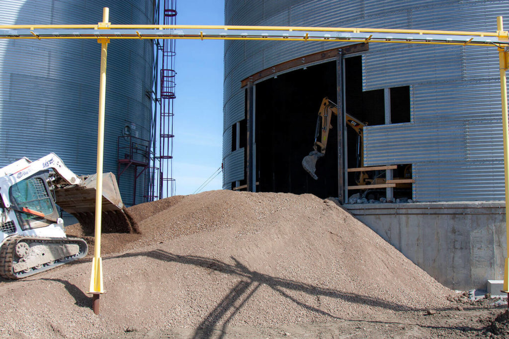 Mini excavator and bobcat removing concrete at FWS site.