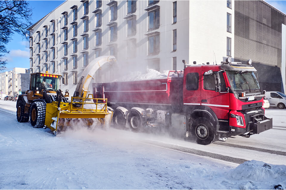 Commercial snow removal services contractor loading snow to be hauled away.