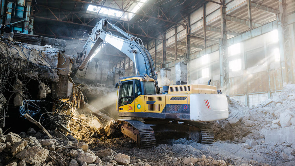 Excavator demolishing a commercial building.