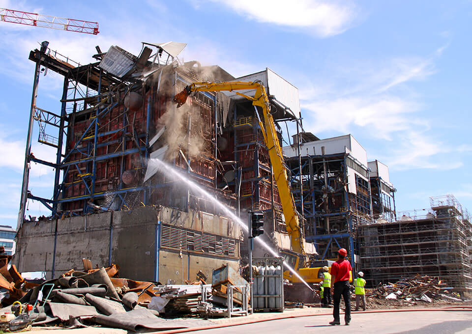 Spraying water at demolition site helps control dust.