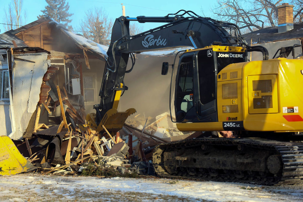 Excavator demolishing a residential building in Regina.