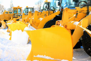 A fleet of tractors with snow removal plows.