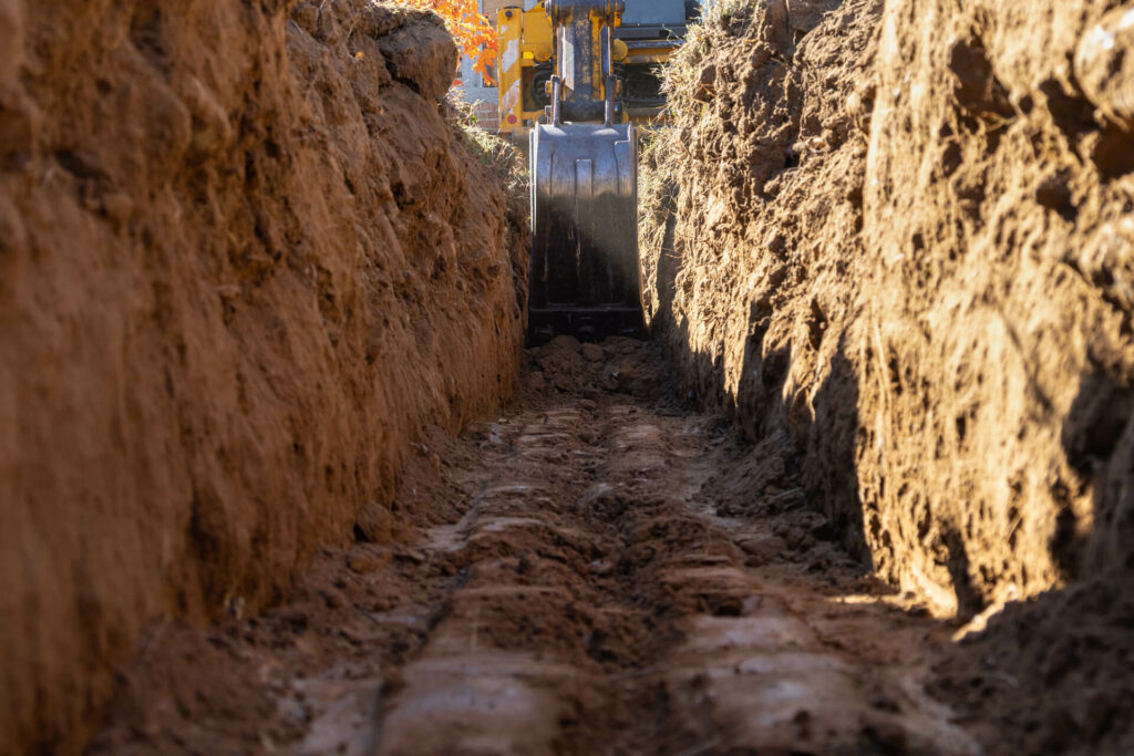 An excavator excavating a trench.